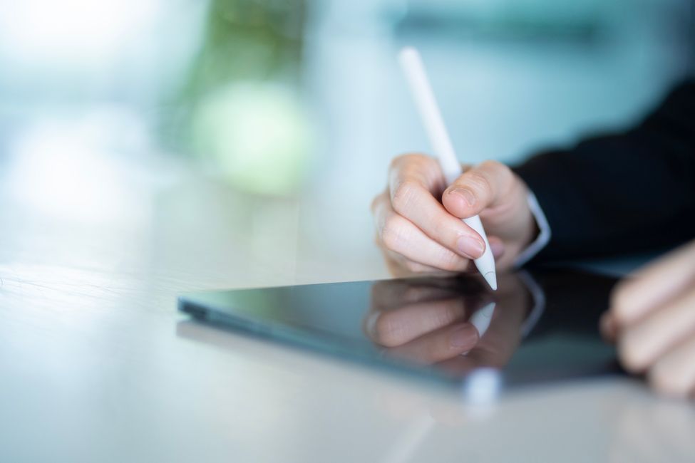 Professionnel consultant des documents numériques sur tablette, illustrant la transition vers la facturation électronique